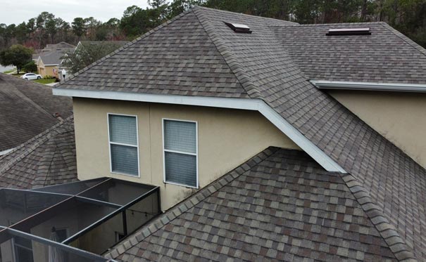 Home with a shingle roof and dormer windows